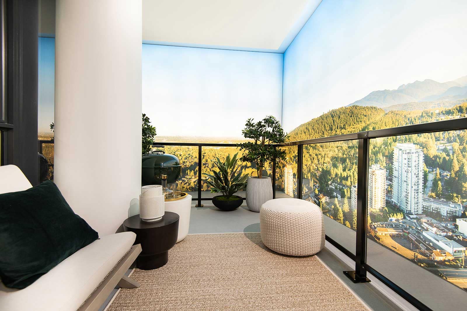 Private balcony at Jinju Coquitlam by Anthem Properties in Burquitlam, 533 Cottonwood Avenue, featuring outdoor seating, planters, and sweeping views of Coquitlam skyline and surrounding mountains.