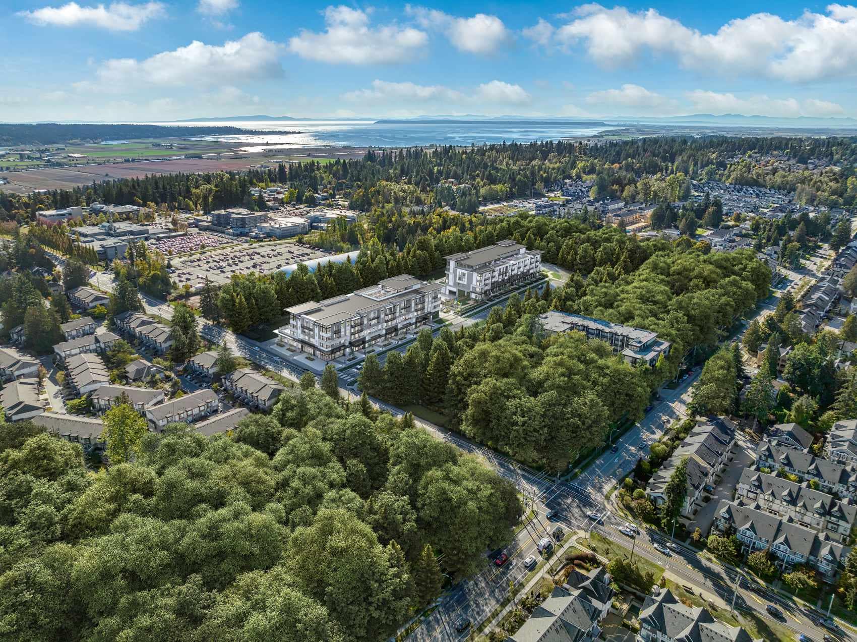 Aerial view of Amson Bloc Surrey presale development by Amson Group showing mid-rise buildings surrounded by greenery, residential neighbourhoods, and nearby farmland in Panorama Ridge, located at 5937 144 Street Surrey