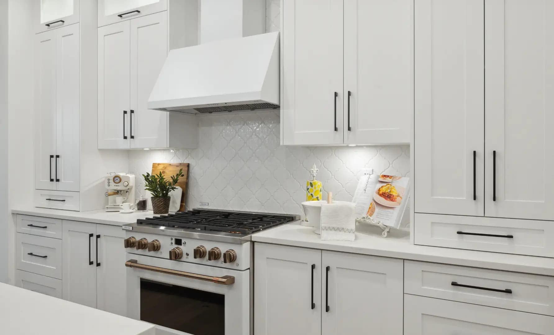 Gourmet kitchen at Brookswood Estates Langley by Foxridge Homes featuring white shaker cabinets, gas range, quartz counters, and designer backsplash at 20826 34A Avenue.