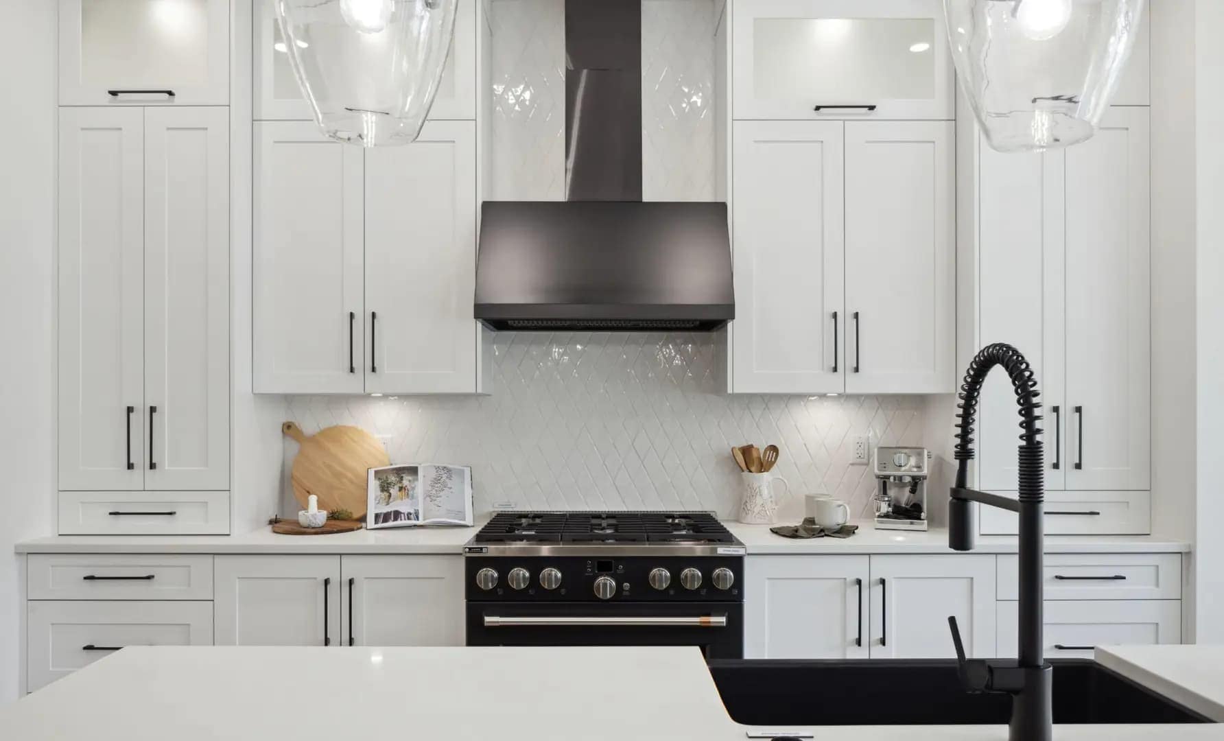 Contemporary kitchen at Brookswood Estates Langley by Foxridge Homes with black range hood, shaker cabinetry, quartz countertops, and oversized island seating.