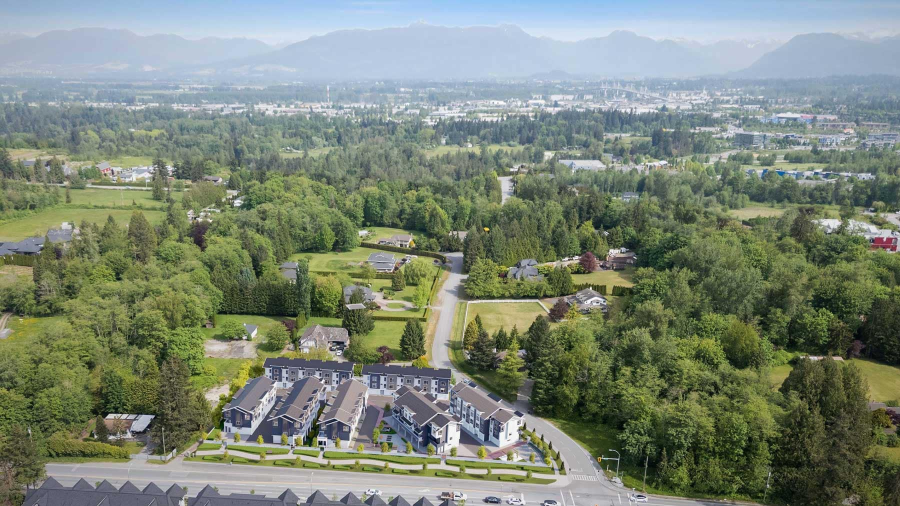 Aerial view of Fiore Langley townhome community by Front Lane Developments at 8039 197 Street, showing the surrounding green space, residential neighbourhood, and mountain backdrop in Langley.