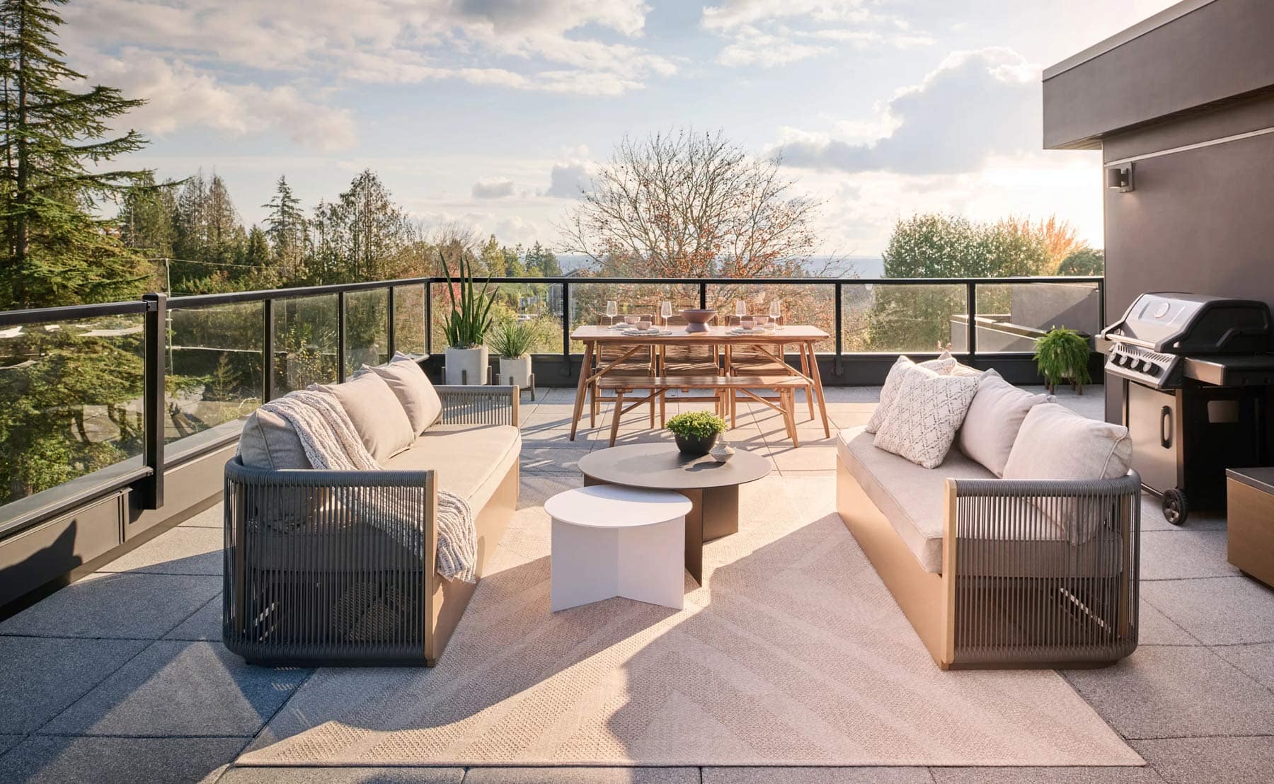 Rooftop patio at Addition Langley development in Willoughby Langley featuring outdoor lounge seating, dining area, BBQ, and scenic views by Redekop Ferrario Properties