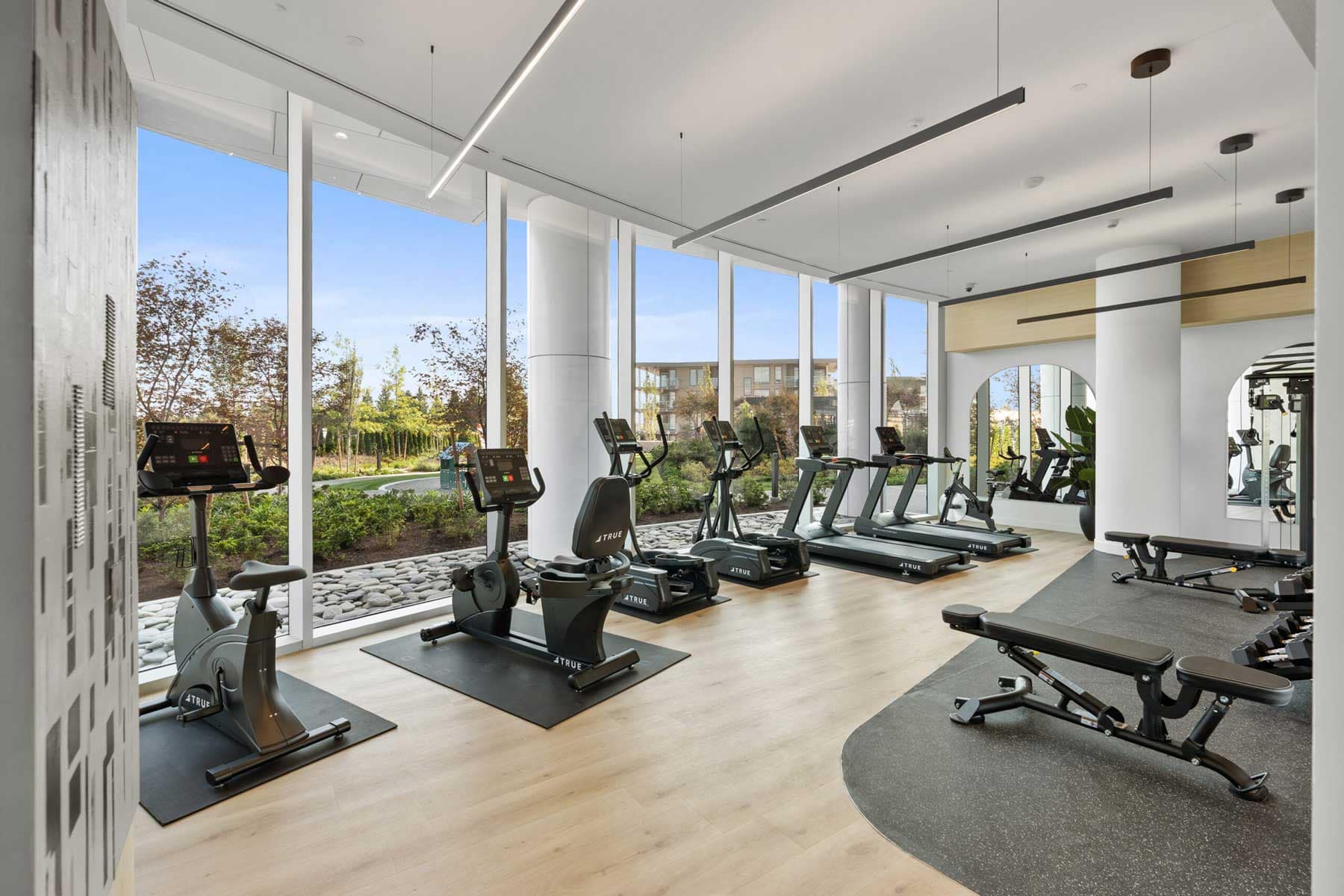 Fitness centre at Icon at Southgate City Burnaby featuring modern cardio and strength equipment overlooking landscaped gardens at 7201 11th Avenue.