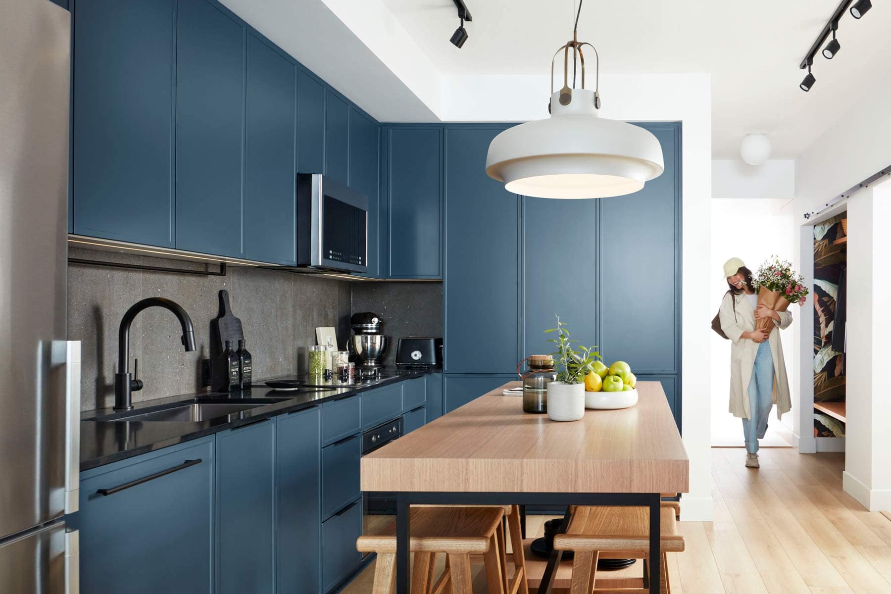 Kitchen at Moody Yards Port Moody showing island seating, cabinetry, and entryway by Mosaic at 3015 Murray Street