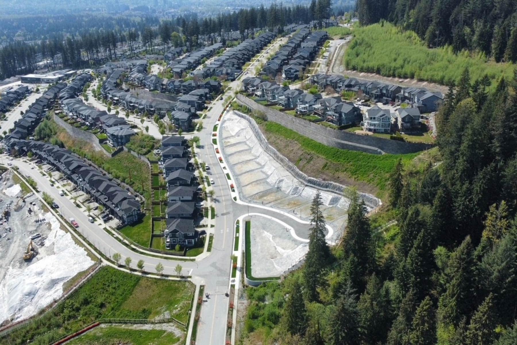 Aerial view of Burke Mountain neighbourhood in Coquitlam showing Timber's Edge development area, surrounding homes, streets, and natural greenbelt