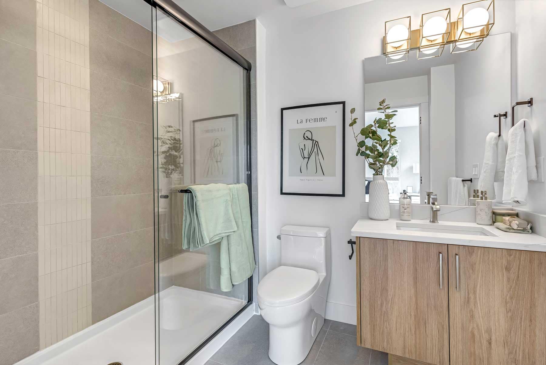 Modern bathroom interior at Park Avenue Langley by Apcon Group with glass shower enclosure, wood vanity, contemporary fixtures, and clean neutral finishes at 7946 204 Street in Langley.