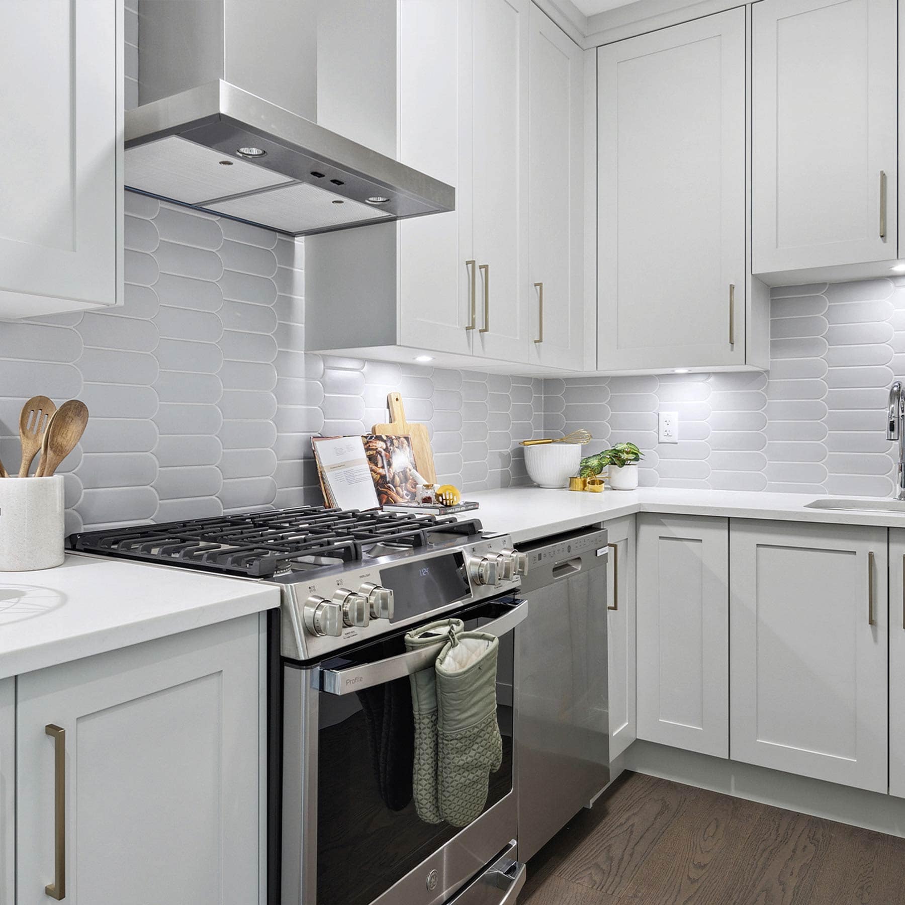 Close-up of kitchen appliances at Timber's Edge Burke Mountain in Coquitlam by Foxridge Homes with gas range, modern cabinetry, and tile backsplash
