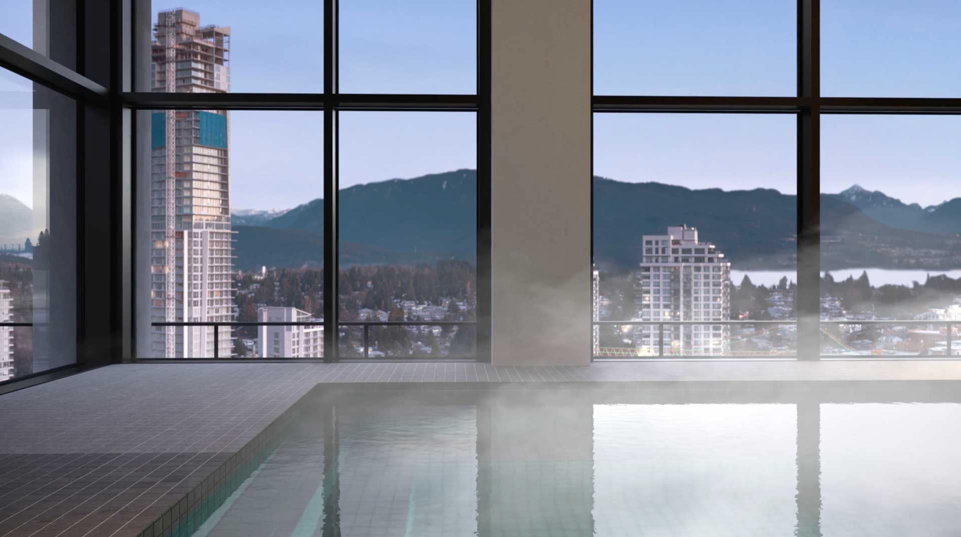 Indoor pool at Jinju Coquitlam presale development by Anthem Properties, located at 533 Cottonwood Avenue in Burquitlam, featuring floor-to-ceiling windows, city skyline views, and North Shore mountains in the background, highlighting luxury wellness amenities.