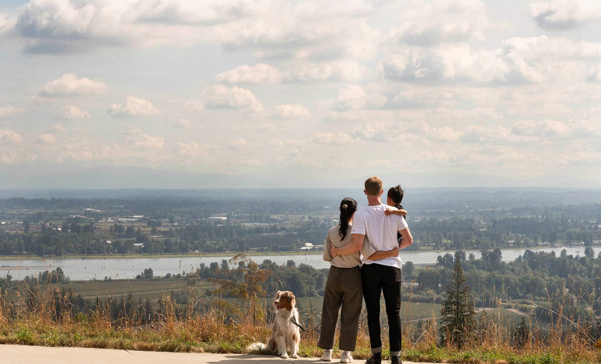 Scenic valley view near Ridgewood Burke Mountain in Coquitlam with a family overlooking the landscape, showcasing elevated views and natural surroundings