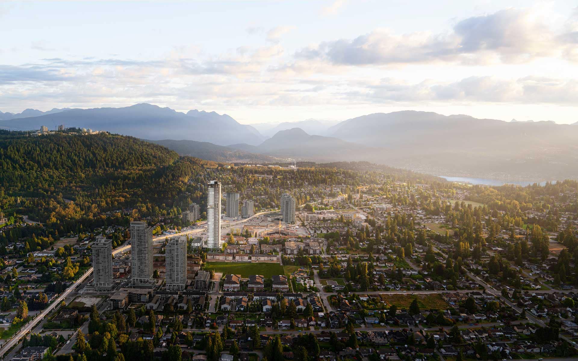 Aerial view of Burquitlam and Coquitlam surrounding Jinju development by Anthem Properties at 533 Cottonwood Avenue, showing residential neighbourhoods, skyline, and mountain backdrop.