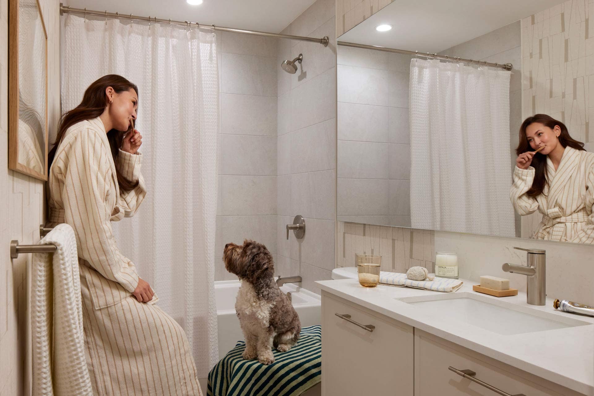 Modern bathroom interior at Town & Centre by Mosaic at 3650 Westwood Street in Port Coquitlam, featuring a tub shower, large mirror, vanity, and contemporary finishes in Coquitlam Town Centre