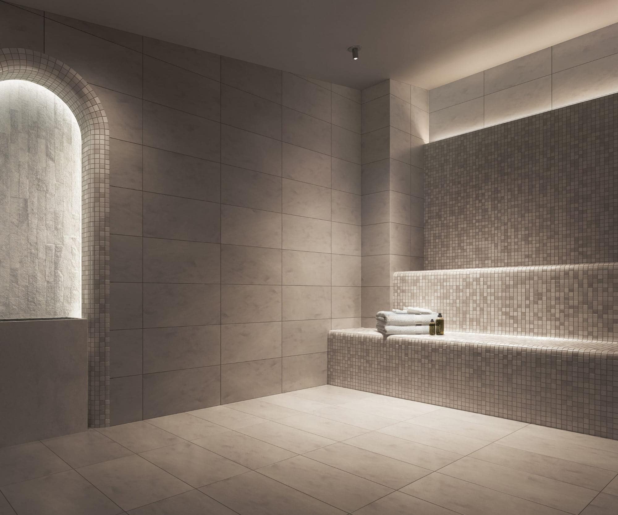 Steam room at Reign Metrotown featuring tiled benches and soft ambient lighting.