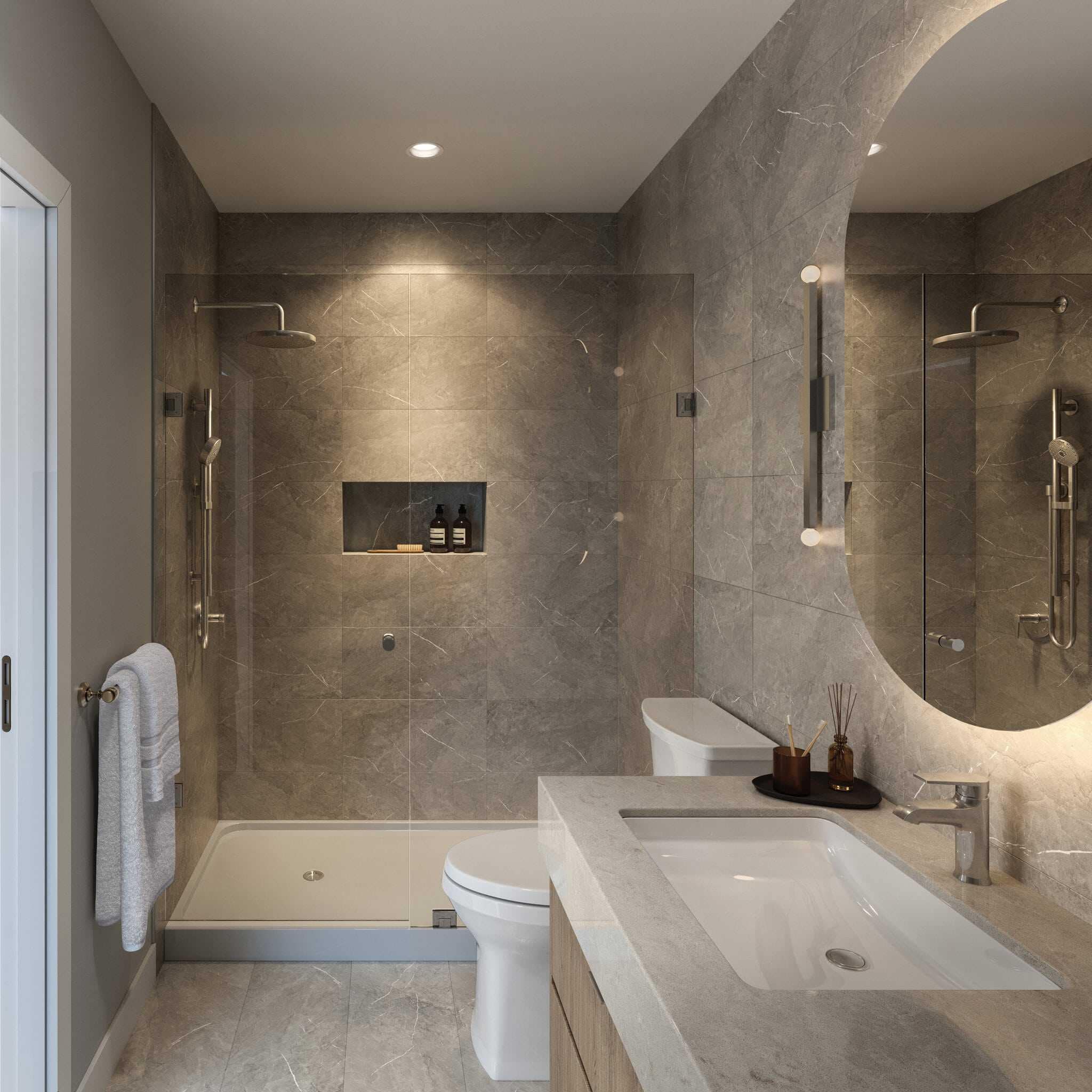 Reign Metrotown ensuite bathroom with large glass shower and curved backlit mirror.