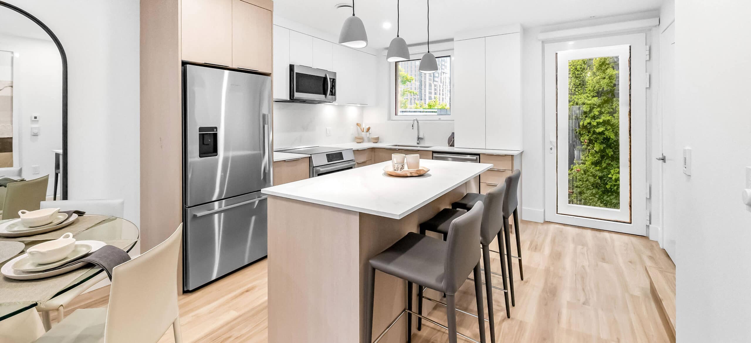 Contemporary kitchen with central island at Lakewood presale development by Dimex Group in Vancouverโs Grandview neighbourhood, showcasing quartz countertops, minimalist cabinetry, pendant lighting, and stainless steel appliances at 2057 East 1st Avenue.