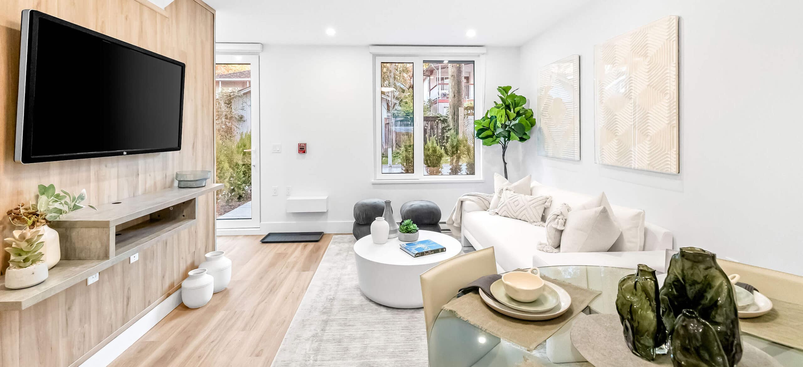 Stylish living room interior at Lakewood, a Dimex Group presale development in Vancouverโs Grandview neighbourhood, featuring a built-in media wall, light wood flooring, soft neutral furnishings, and modern dรฉcor at 2057 East 1st Avenue.
