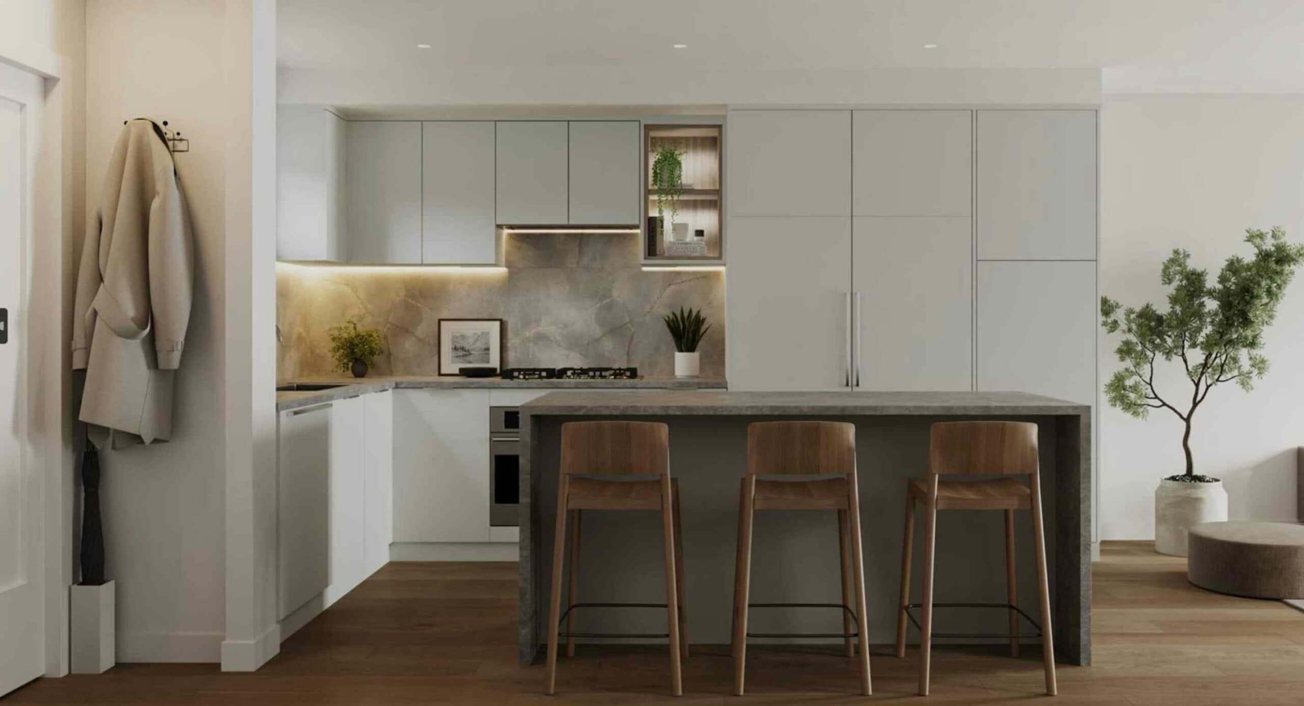 Modern kitchen interior at Hendry in East Vancouver with oversized island, sleek cabinetry, integrated lighting, stone backsplash, and warm wood accents at 3839 Commercial Street, developed by Trillium Projects.