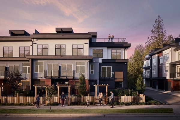 Townhome streetscape at Addition Langley in Willoughby by Redekop Ferrario Properties at 20335 70a Ave, featuring modern architecture, rooftop terraces, landscaped walkways, and residents along the sidewalk at sunset.