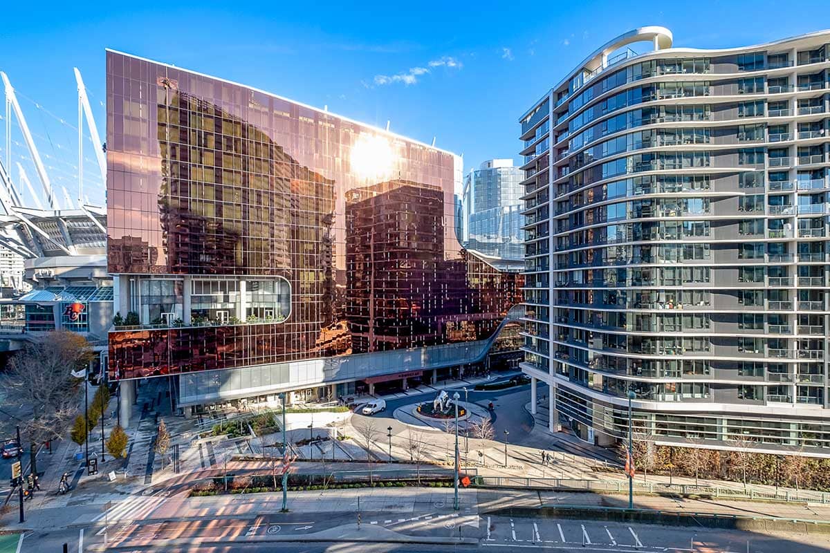 Modern condos in downtown Vancouver with curved architecture and reflective glass facade, near BC Place Stadium.
